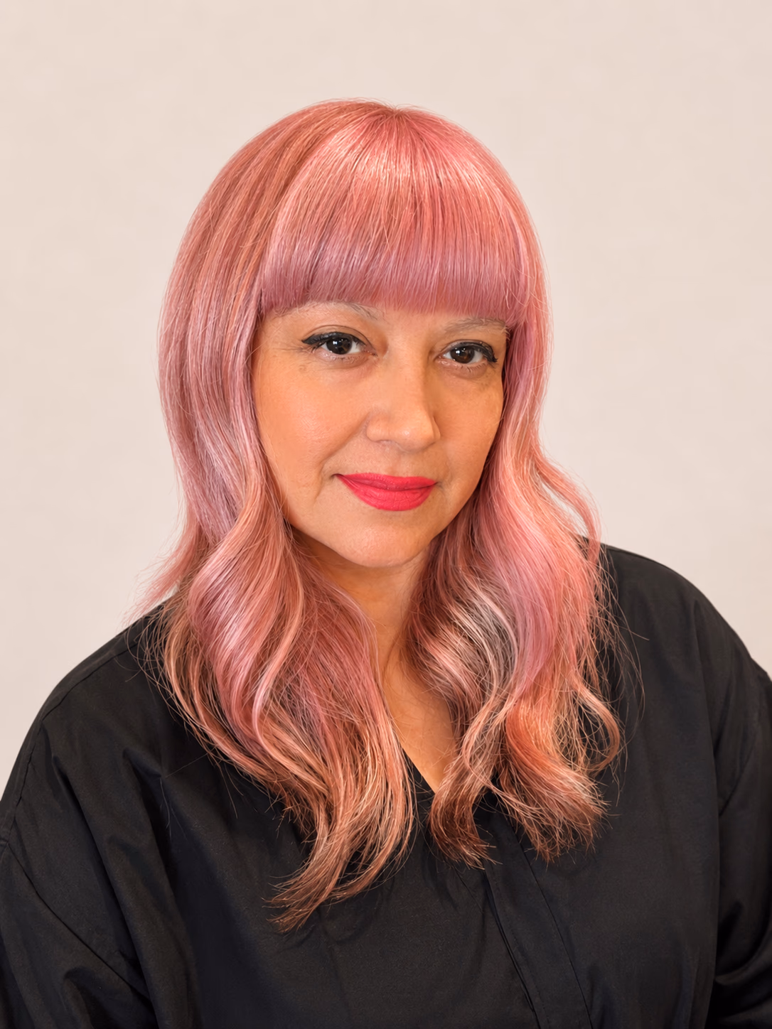 Soft pink all-over color on long waves with a blunt fringe.